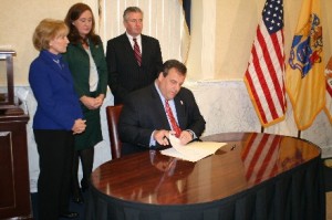 Governor Chris Christie signs his letter to President Obama requesting FEMA disaster relief this moring at the Monmouth County Hall of Records.  Assembly Members Mary Pat Angelini, Caroline Casagrande and Dave Rible, background.