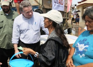 Cong. Smith, chairman of the House global health and human rights subcommittee, joins a clean water distribution line operated by Catholic Relief Services and U.S. Agency for International Development (USAID) to talk with victims of the typhoon. CRS distributed 520 hygiene kits at San Joaquin Catholic Church in the village of San Joaquin, outside of Palo on the island of Leyte. The kits include items like collapsible water jugs, water purification tablets and soap. Handing out hygiene kits are Congressmen Al Green (D-TX) in green shirt, and Chris Smith R-NJ blue/white striped shirt. Photo Credit: Jim Stipe/Catholic Relief Services 