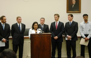 Bindu Phillips of Plainsboro, N.J. addresses media at a Capitol Hill press conference. From left in rear are other “left-behind” parents Barton Hermer of Texas, Paul Toland of Maryland, Rep. Chris Smith, David Goldman of  N.J., Dennis Burns of Colorado, and Arvind Chawdra of N.J.