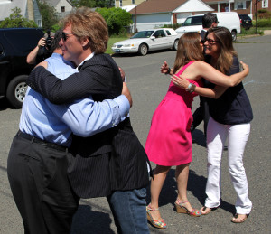 Governor Chris Christie gets a hug from rock legend Jon Bon Jovi while First Lady Mary Pat Christie gets a hug from Mr. Bon Jovi's wife Dorothea before announcing a one million dollar donation to the Hurricane Sandy New Jersey Relief Fund from Jon Bon Jovi at Borough Hall in Sayreville, N.J. on Monday, July 8, 2013. (Governor's Office/Tim Larsen)