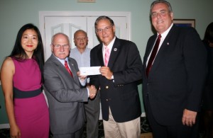 Assembly Republican Leader Jon Bramnik (center-right) presents a check to the "Positively Marlboro" GOP candidates, Sui Allex for Council, Ira Goldberg for Mayor and Council candidate John Dwyer, far right, as campaign treasurer Mario Giudice licks his lips