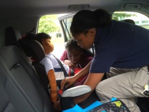 Sheriff's Officer Michelle Melendez demonstrating the proper installation of a child safety seat.